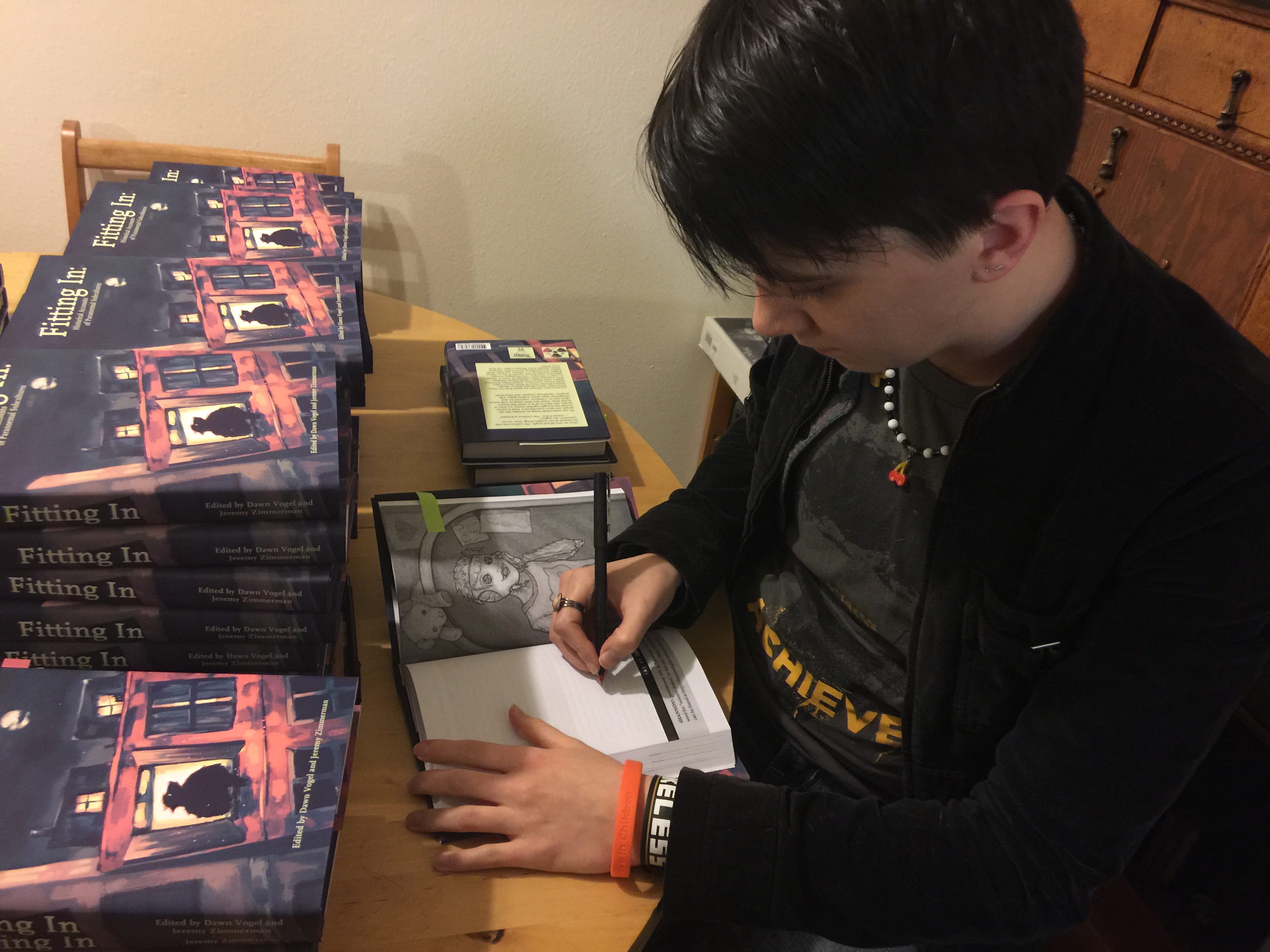 Photo of Artist Shannon Legler signing copies of Fitting In.