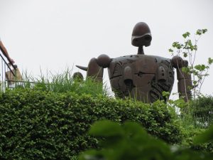 Robot towering over hedges