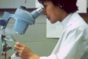 Female scientist looking through a microscope